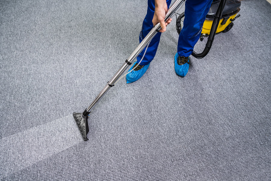 man vacuums the dirty mat